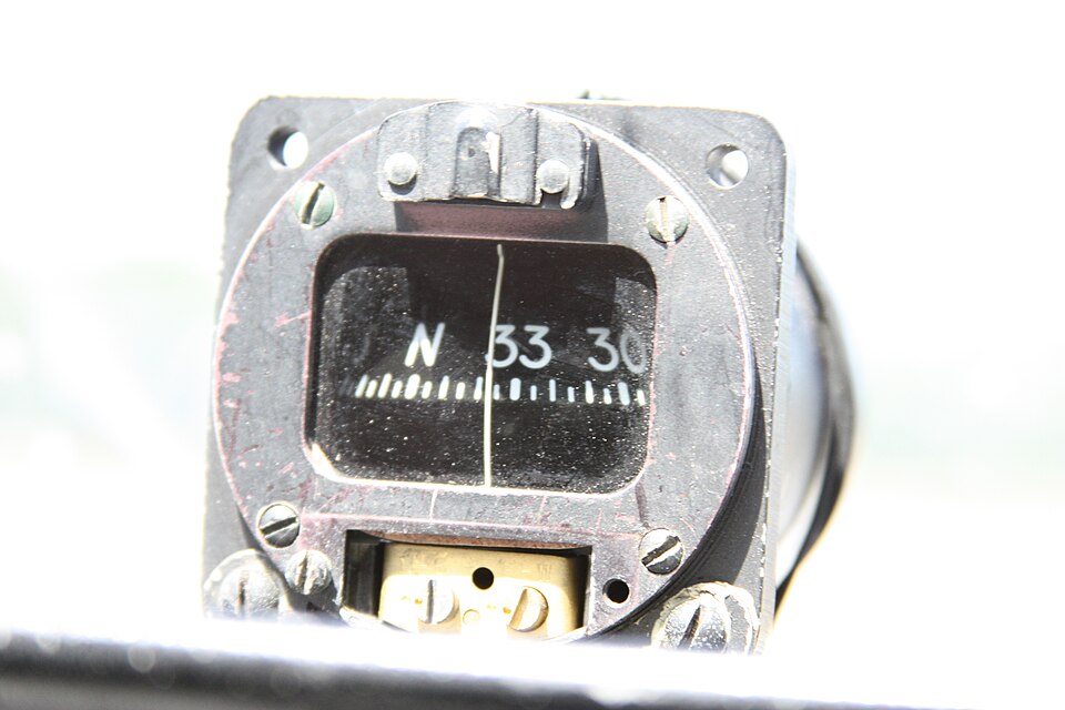 Compas magnétique « whiskey compass » monté dans un Cessna C172, cadran affichant N 33 30 derrière la fenêtre du lubber line