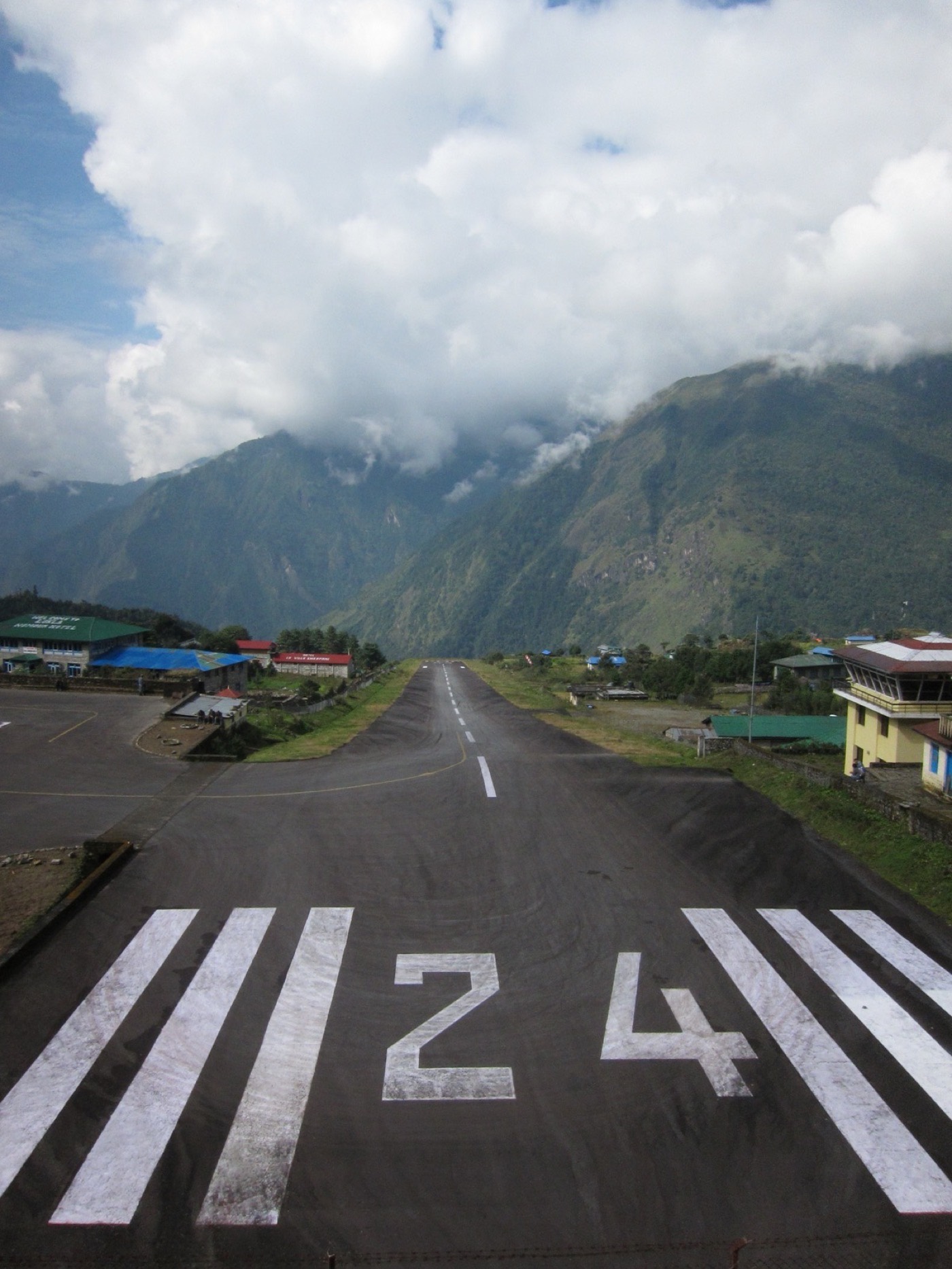 Piste de l'aéroport de Lukla au Népal, environ 500 m de long, avec une falaise à une extrémité et une montagne à l'autre