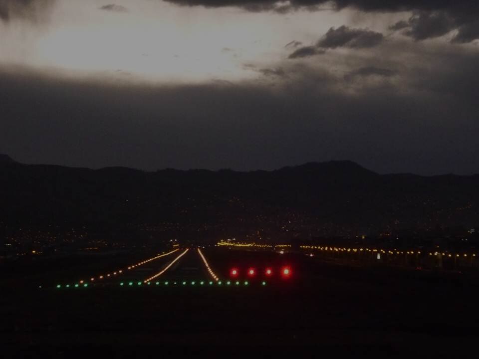 Approche de nuit vers une piste : rangées de feux de bord de piste et rangée de feux PAPI visible sur le côté